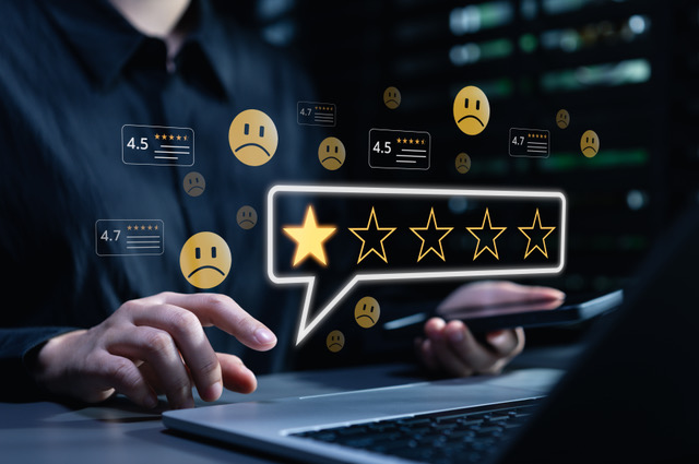 Person on a laptop and phone surrounded by a one-star rating and unhappy faces, showing the cost of poor customer service